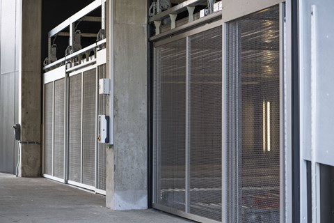 a row of metal doors on the side of a building at Analog PDX Apartments, Portland, OR 97227