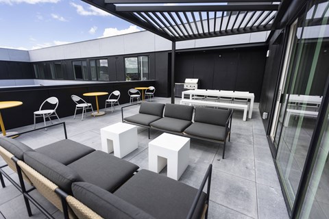 a patio with couches and tables on a balcony at Analog PDX Apartments, Portland
