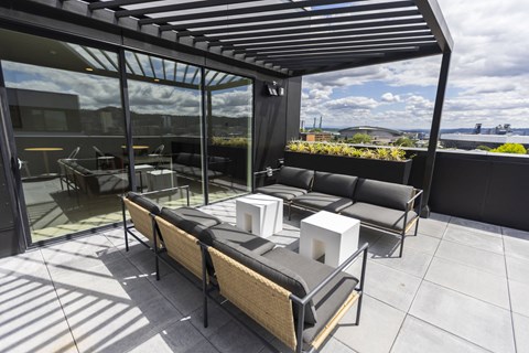 a large patio with couches and tables on a roof at Analog PDX Apartments, Oregon 97227