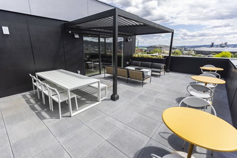 a rooftop patio with a table and chairs and a canopy at Analog PDX Apartments, Portland, OR 97227