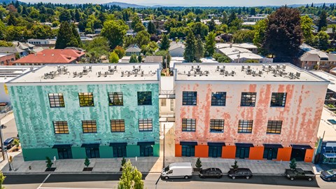 Two buildings with different colored facades are shown from an aerial perspective.