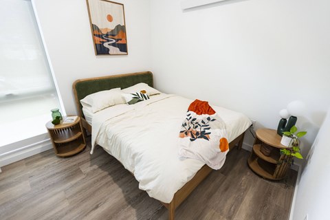 a bedroom with a bed with a white comforter and pillows at Brookland Apartments, Oregon 97202