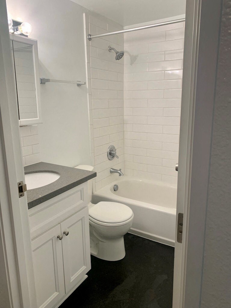 a bathroom with a toilet and a tub and a sink
