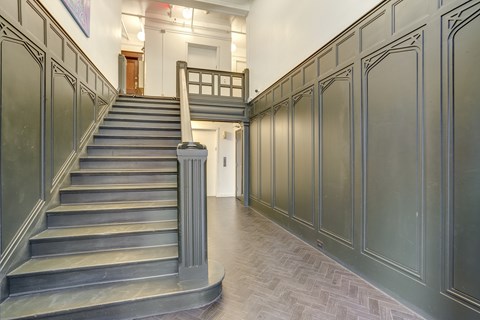 A staircase with a metal railing and steps leading to a doorway at Clay & Tiffany, Portland, 97201