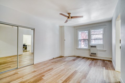 A room with a ceiling fan and a window.