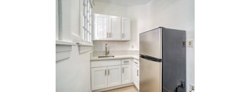 A kitchen with white cabinets and a black refrigerator at Clay & Tiffany, Portland, 97201