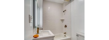 A white bathroom with a sink, mirror, and bathtub at Clay & Tiffany, Portland, 97201