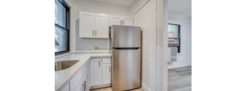 A kitchen with a stainless steel refrigerator and white cabinets at Clay & Tiffany, Portland, 97201