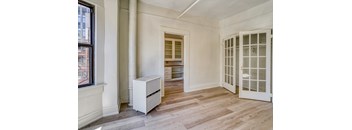 A white cabinet with drawers is in a room with a window and a door at Clay & Tiffany, Portland, 97201