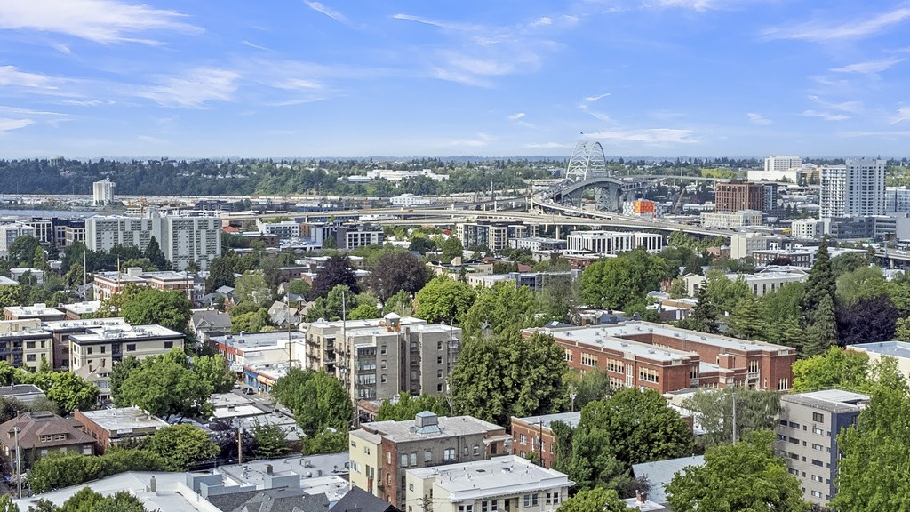 an aerial view of the city with a bridge in the background