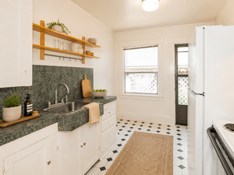 A kitchen with white cabinets and a green counter top.