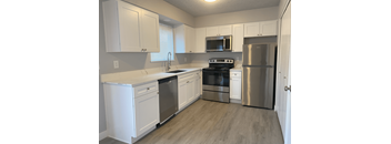 a kitchen with stainless steel appliances and white cabinets