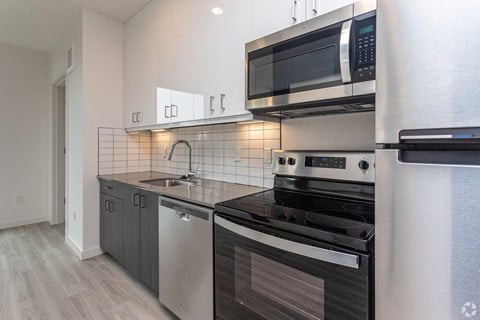A modern kitchen with a stainless steel dishwasher and oven.