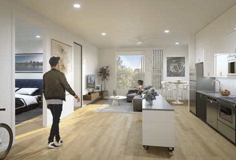 Person entering bedroom from open concept living area at Kaya Camilla Apartments, Oregon
