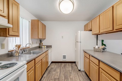 A kitchen with wooden cabinets and a white refrigerator.
