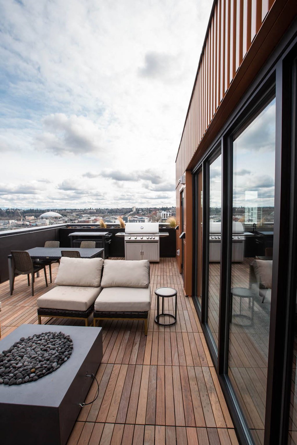 a deck on the roof of a building with furniture and a grill at Analog Tacoma, Tacoma