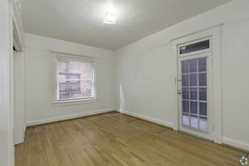 a bedroom with a door and a window and a wooden floor at Clay & Tiffany, Portland, OR