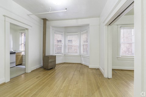 an empty living room with wood floors and a bay window at Clay & Tiffany, Portland, OR, 97201