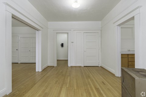 a living room with white walls and doors and a wood floor at Clay & Tiffany, Portland, OR, 97201