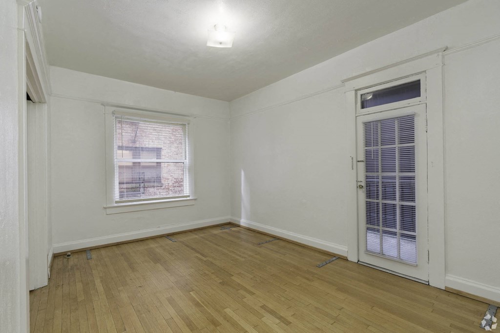 the living room of an empty home with white walls and wood floors at Clay & Tiffany, Portland, OR