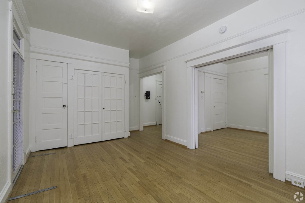 the living room and dining room with white doors and wood flooring at Clay & Tiffany, Portland, 97201