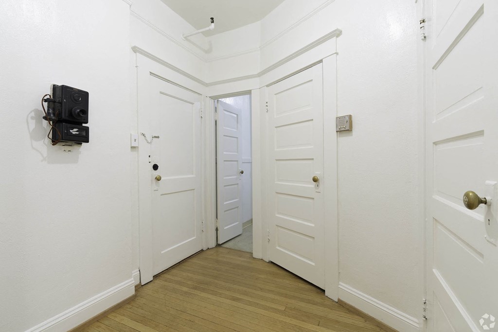 a white hallway with white walls and a door with a black box on the wall at Clay & Tiffany, Portland, OR