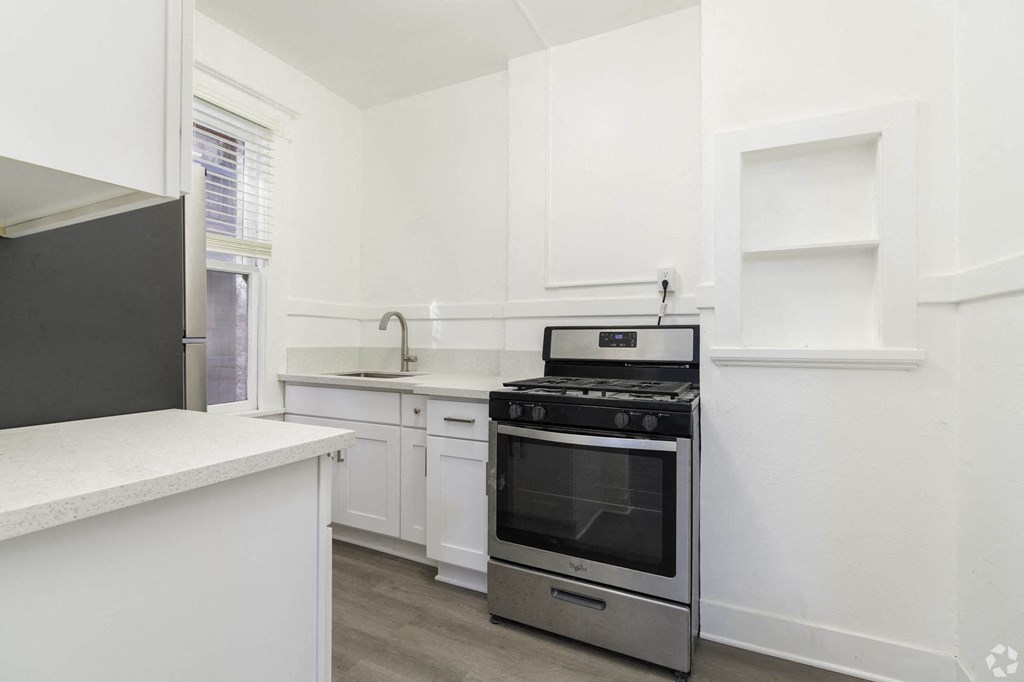 a white kitchen with stainless steel appliances and white cabinets at Clay & Tiffany, Portland, OR