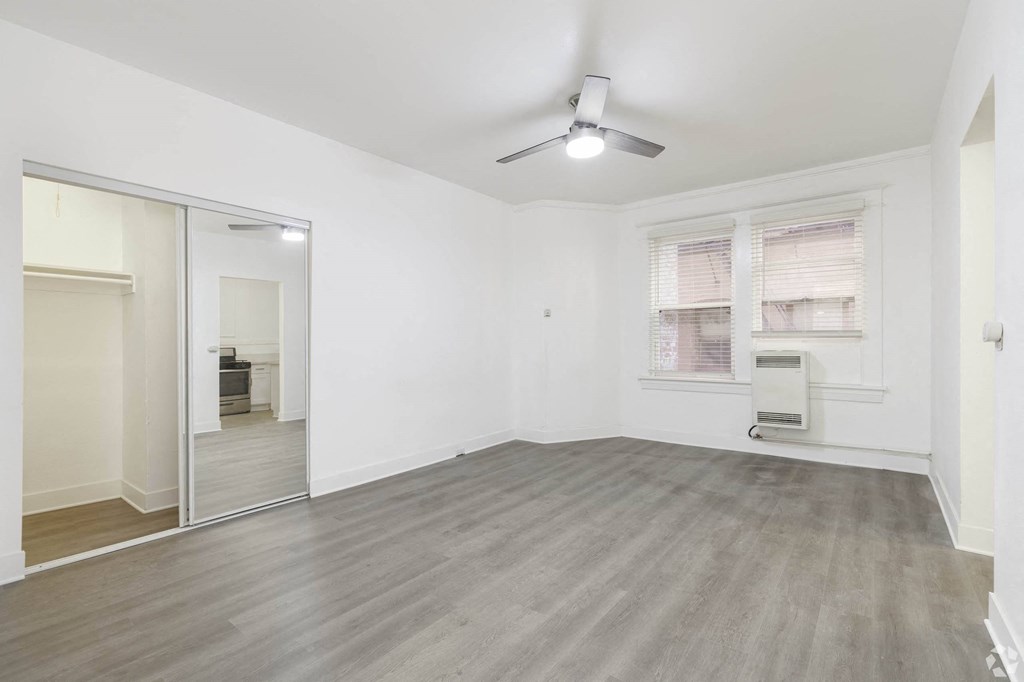 an empty living room with a mirrored closet and a ceiling fan at Clay & Tiffany, Portland, 97201