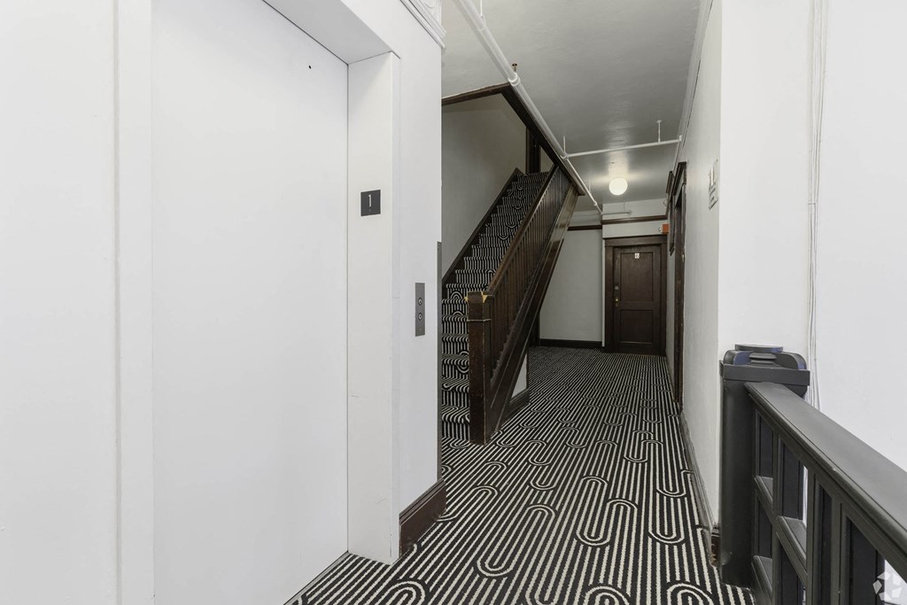 a hallway with stairs and a black and white geometric flooring at Clay & Tiffany, Portland, OR, 97201
