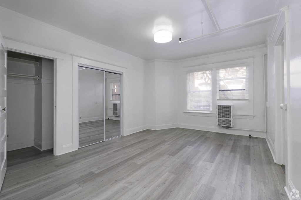 an empty living room with white walls and a mirrored closet at Clay & Tiffany, Portland, OR