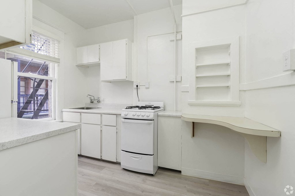 a white kitchen with a stove and a window at Clay & Tiffany, Portland, OR