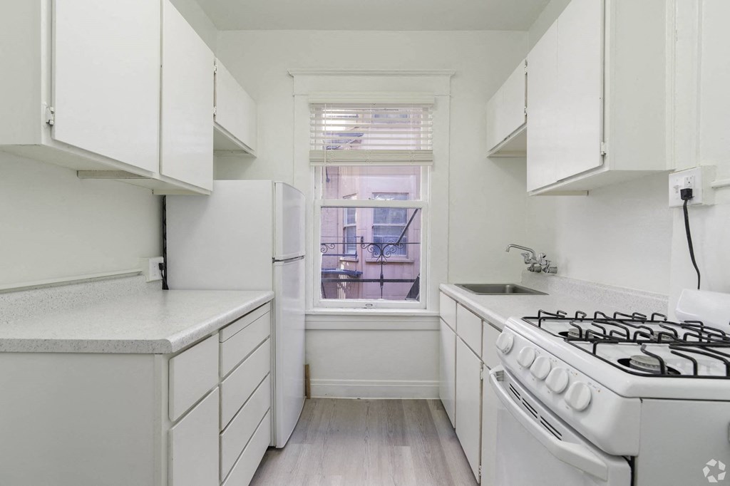 a white kitchen with a stove and a window at Clay & Tiffany, Portland, OR