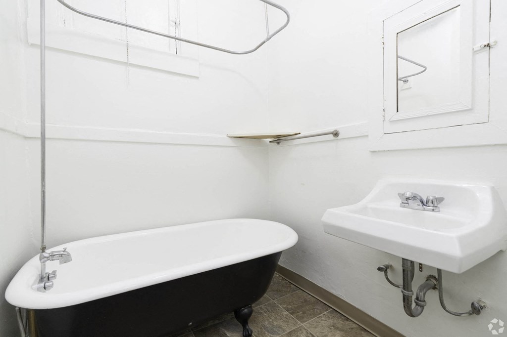 a white bathroom with a black bath tub and a sink at Clay & Tiffany, Portland, OR