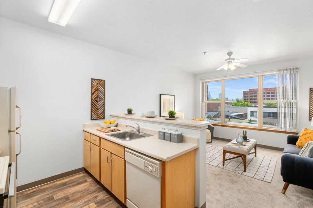 A kitchen with wooden cabinets and a white countertop.at Fifth Avenue Place Apartments, Oregon