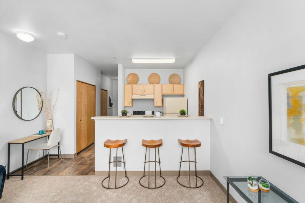 A modern kitchen with a bar area and stools.at Fifth Avenue Place Apartments, Portland, OR
