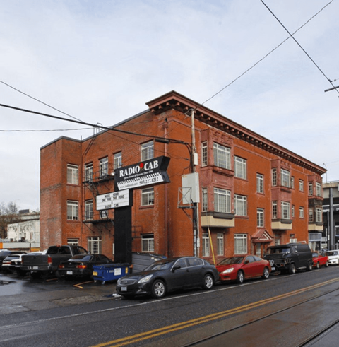 A red brick building with a sign that says Radio Cab. at Midtown Apartments, Oregon