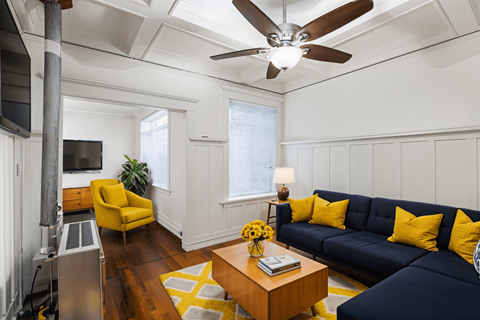 A living room with a yellow chair and a blue couch.