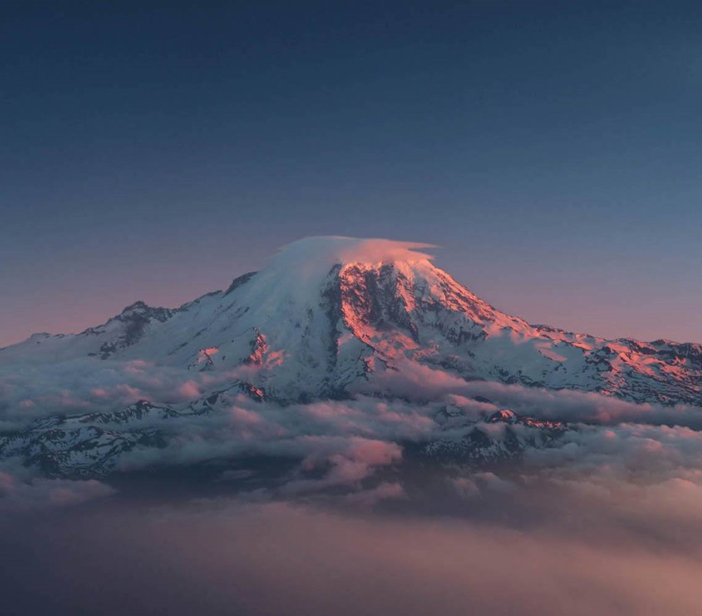 A snow-covered mountain peak rises above the clouds at Garden Villa Apartments, Portland, OR, 97266