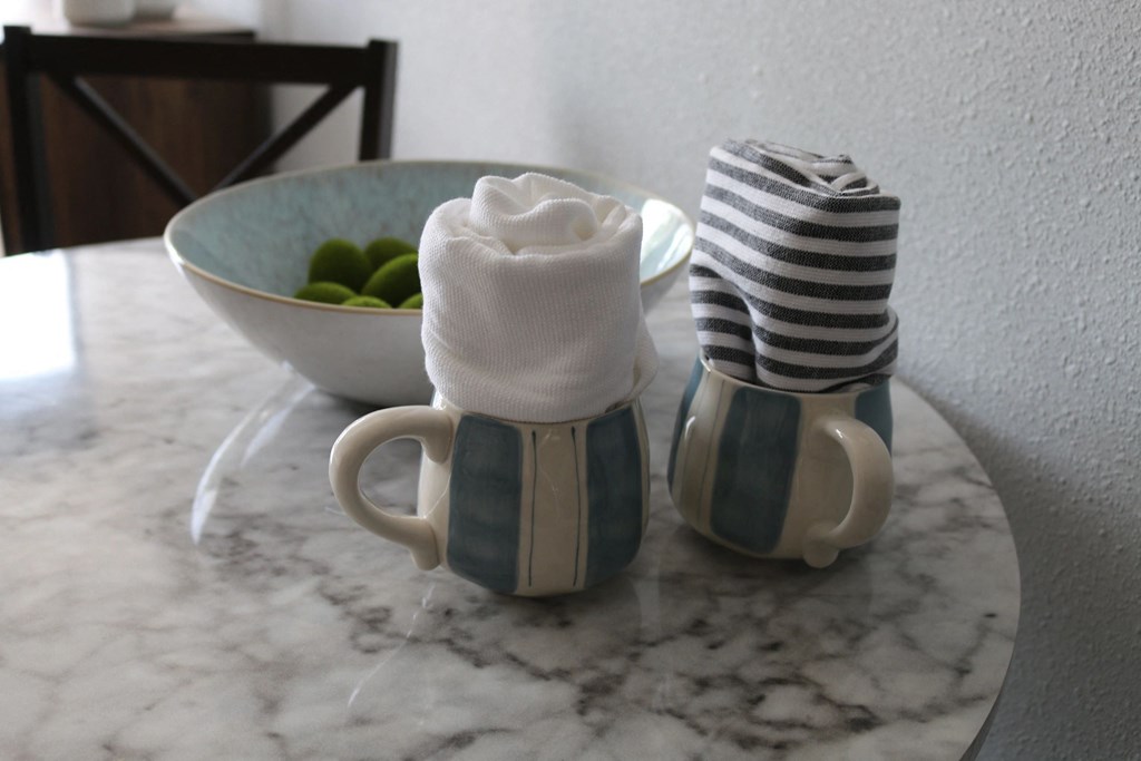two coffee mugs with towels and a bowl of fruit on a table at Schaefer Ridge Apartments, Missouri, 65616
