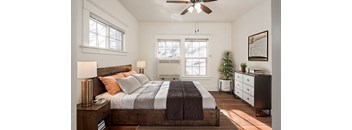 A bedroom with a bed, nightstand, and a ceiling fan.