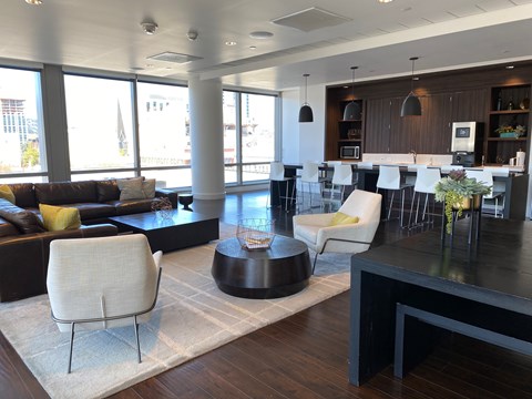 A modern living room with a black coffee table and white chairs.
