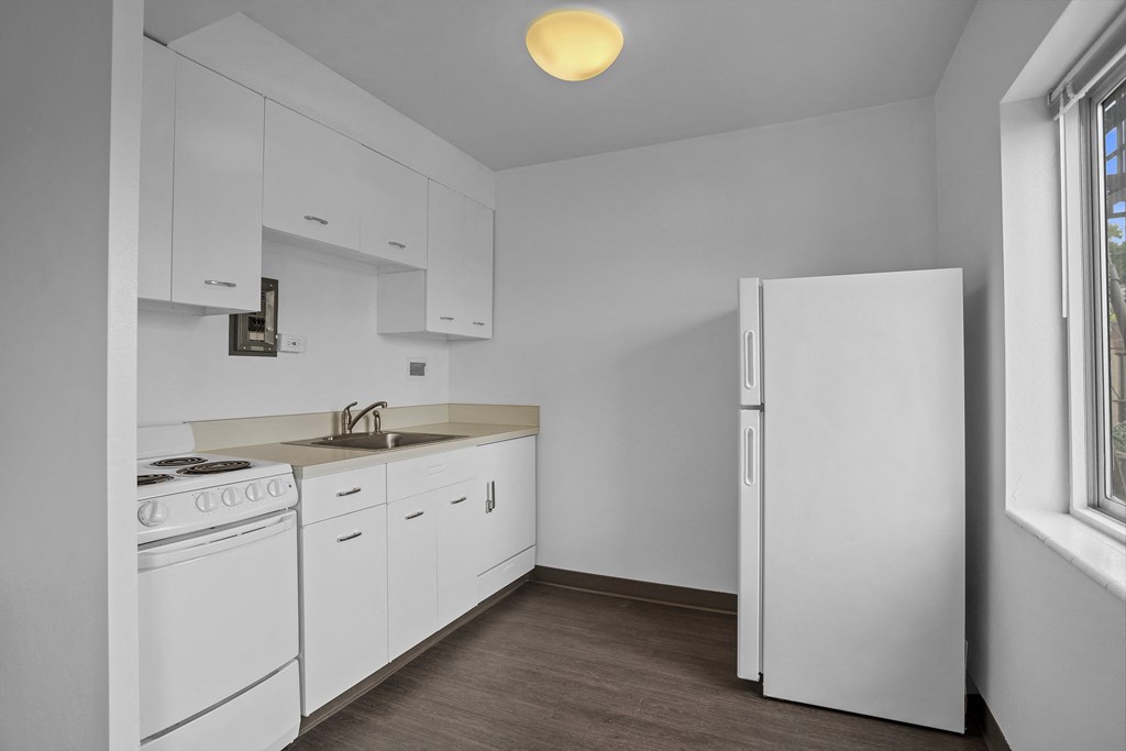 a kitchen with white appliances and white cabinets and a white refrigerator