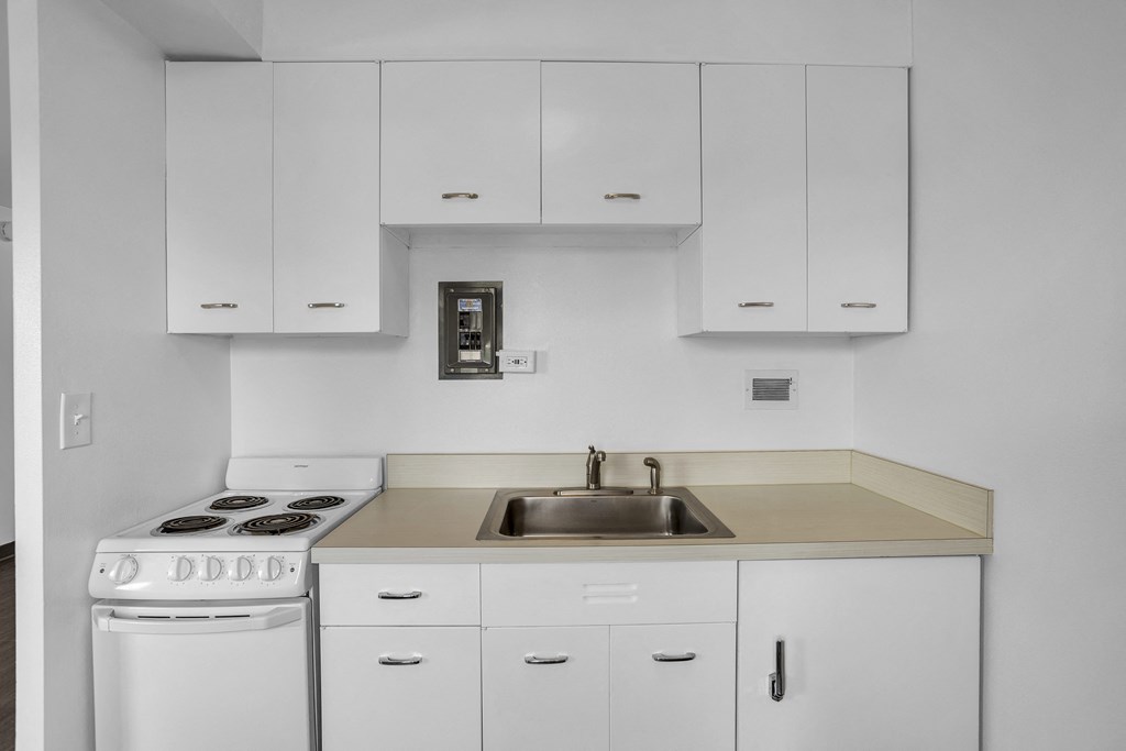 a kitchen with white cabinets and white appliances and a sink