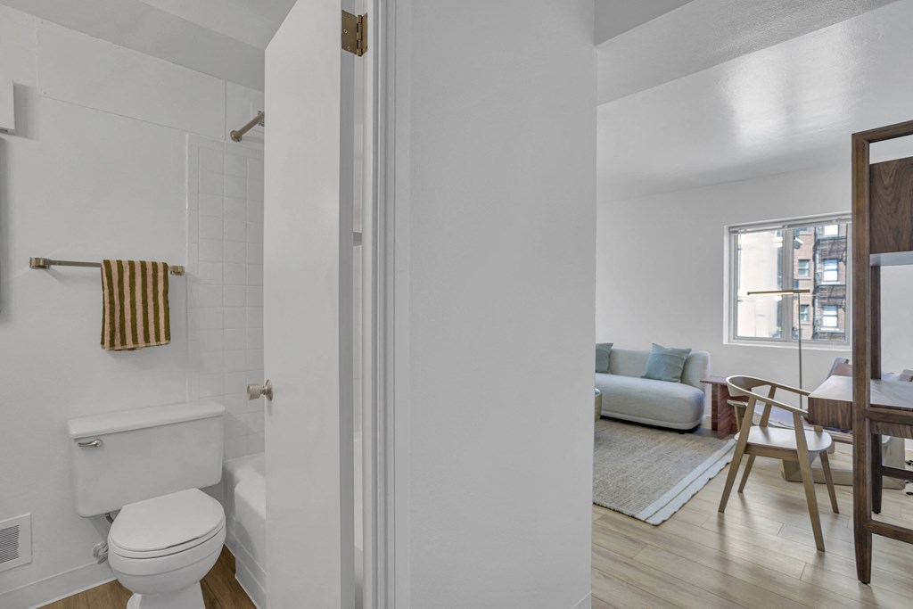 a bathroom and a living room with a couch and a table