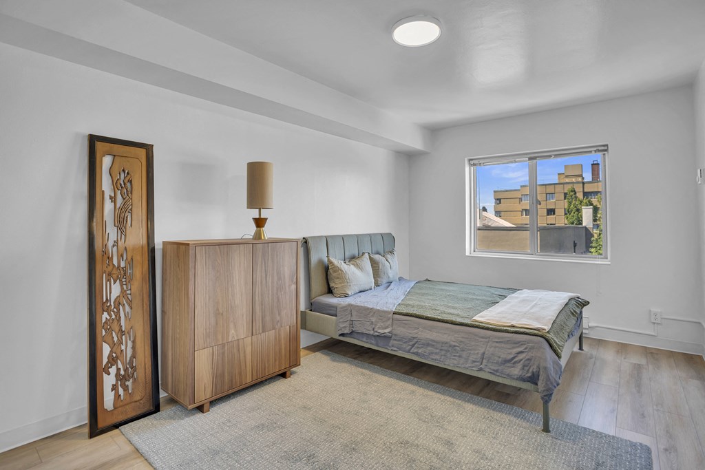 an empty bedroom with a bed and a window