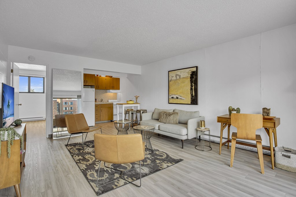 a living room with a couch and chairs and a dining room and a kitchen