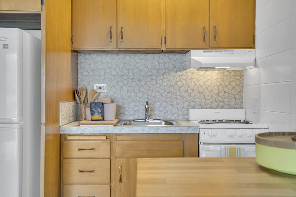 a kitchen with white appliances and wooden cabinets