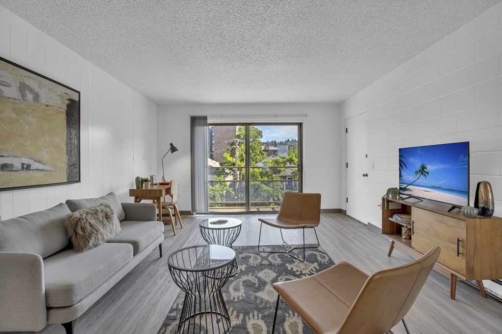 a living room with a couch and chairs and a tv
