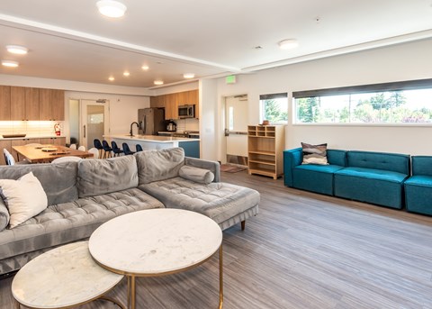 A modern living room with a grey sofa and a round marble table.