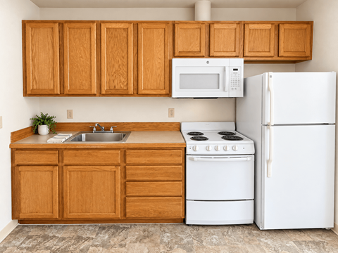 A kitchen with white appliances and wooden cabinets.